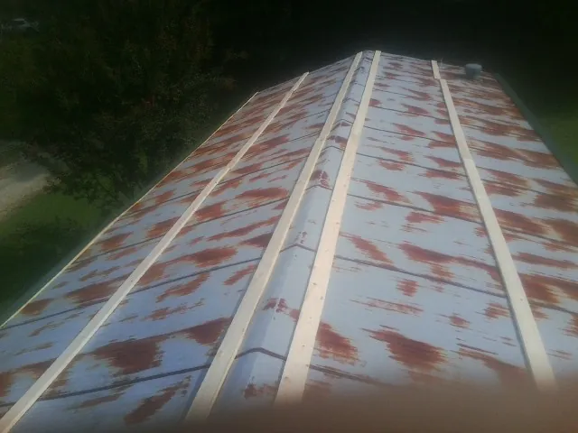Rusted metal roof panels with new wood purlins before replacement — Storm Damage Roof Repair in Valdosta by Roofing Brothers