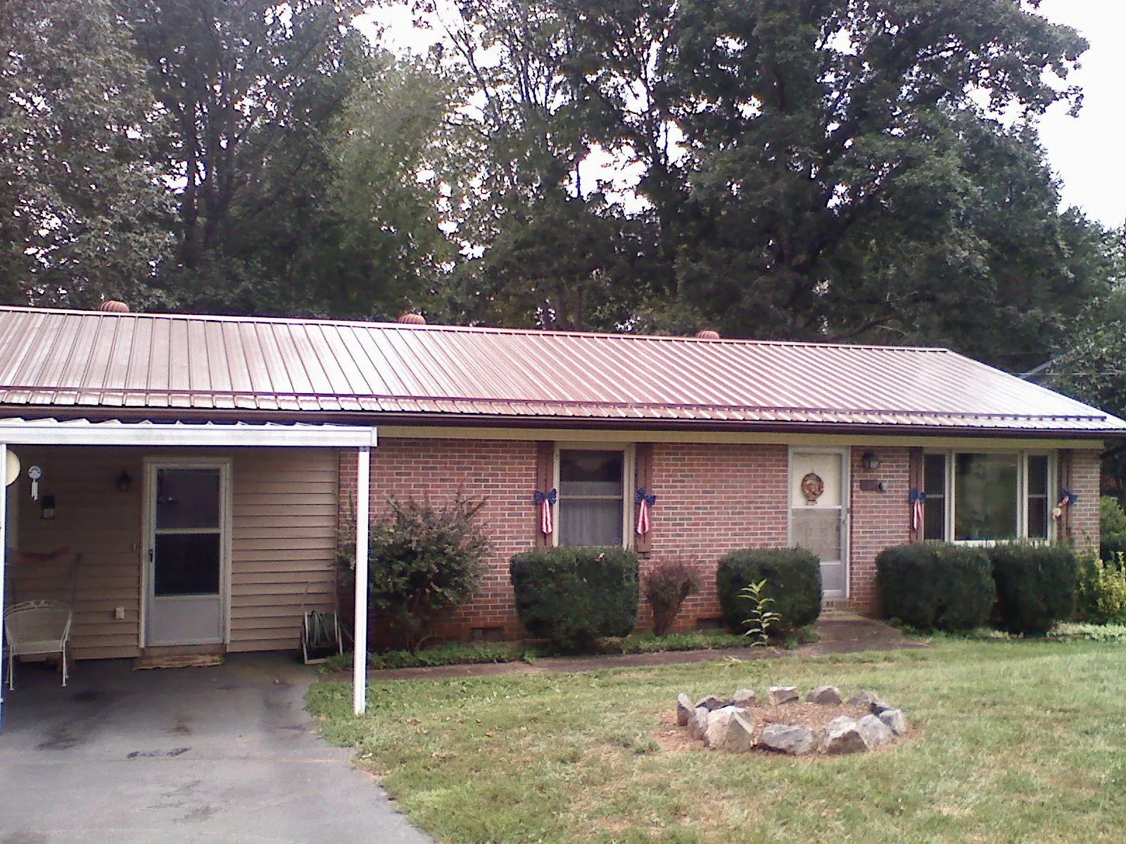 Bronze metal roof and carport on a brick ranch home — Roof Repair work by our crew in Valdosta