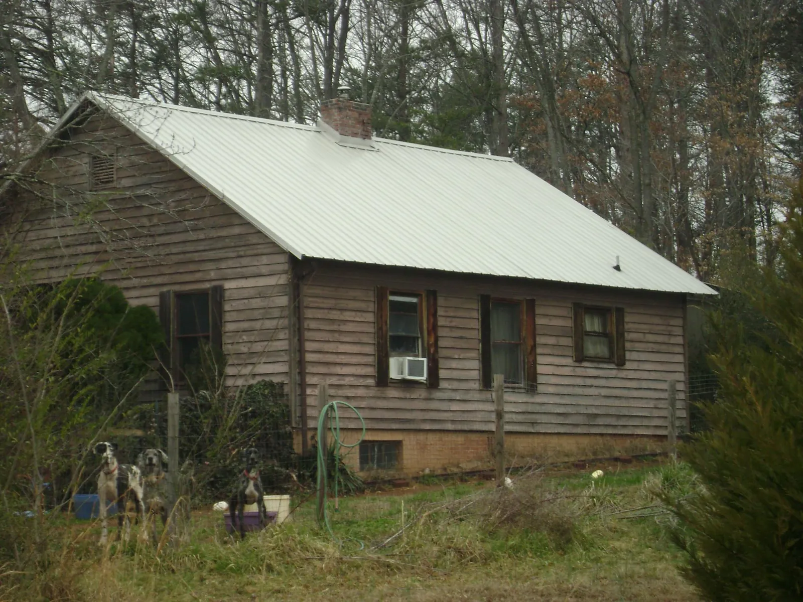 White metal roof on an old wood sided farmhouse, from a Metal Roof Installation job in Valdosta